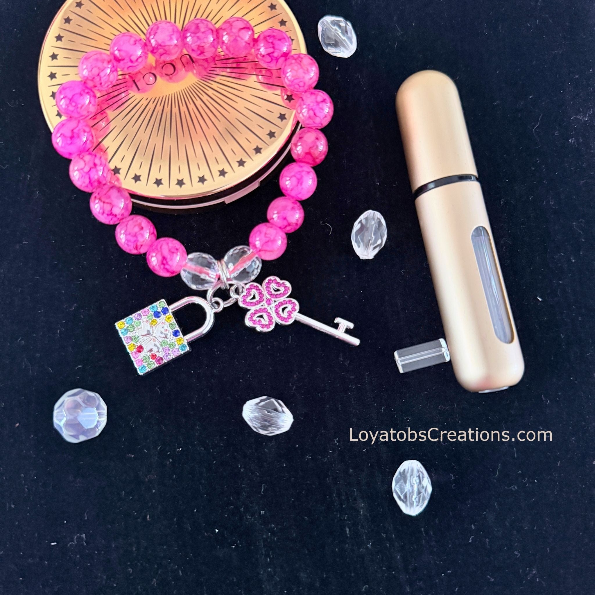 Hot pink crackle bead bracelet with multicolour rhinestone padlock and pink heart key charms flat lay on dark background - LoyatobsCreations.com