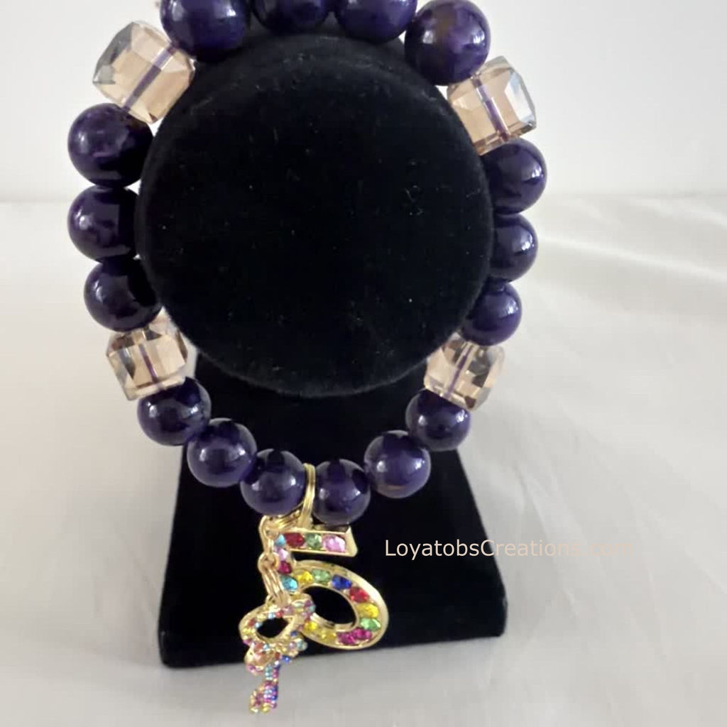 Purple bead and champagne cube crystal charm bracelet displayed on black jewellery stand - LoyatobsCreations.com
