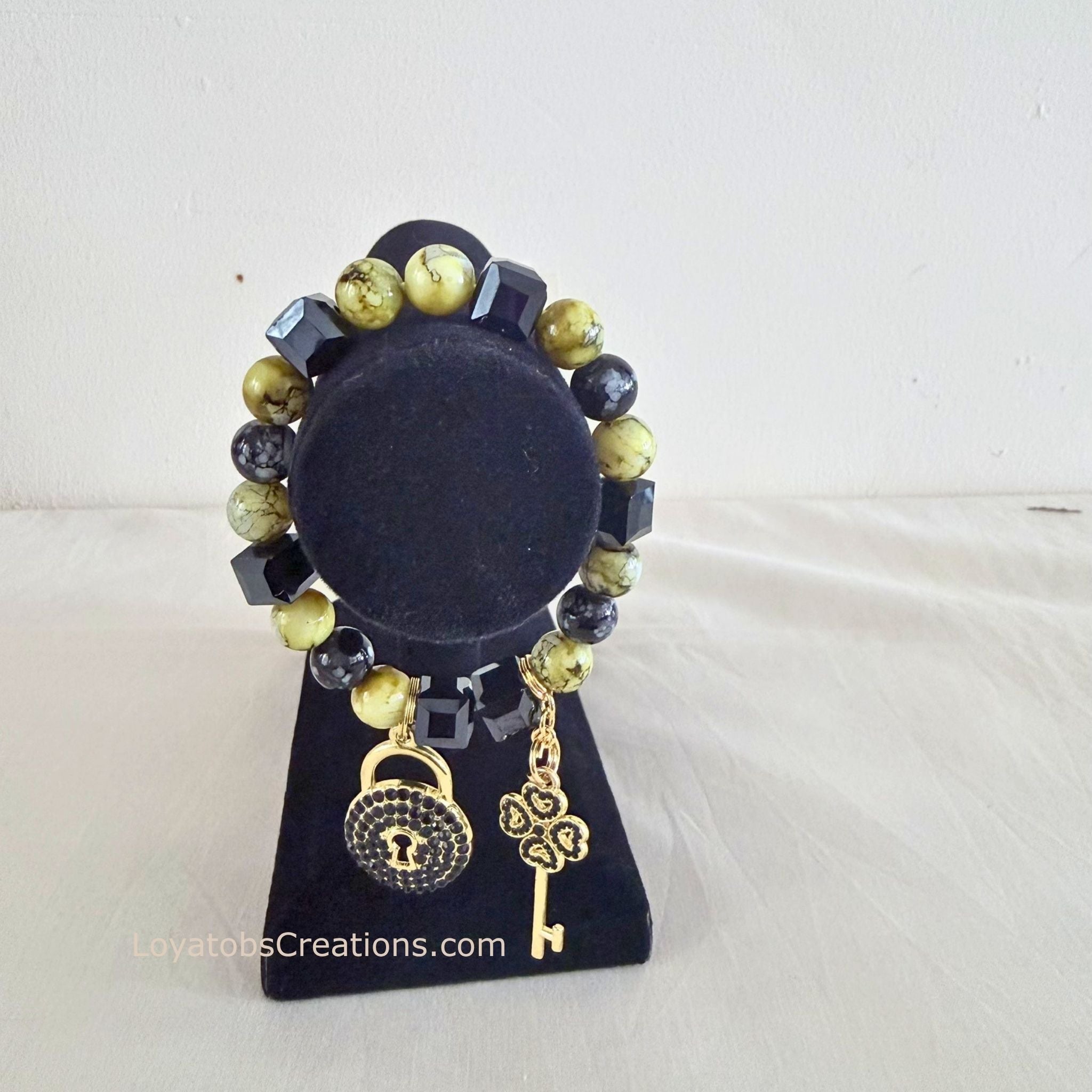 Lime and black cube bead bracelet with gold pavé lock and clover key charms on black jewellery stand - LoyatobsCreations.com