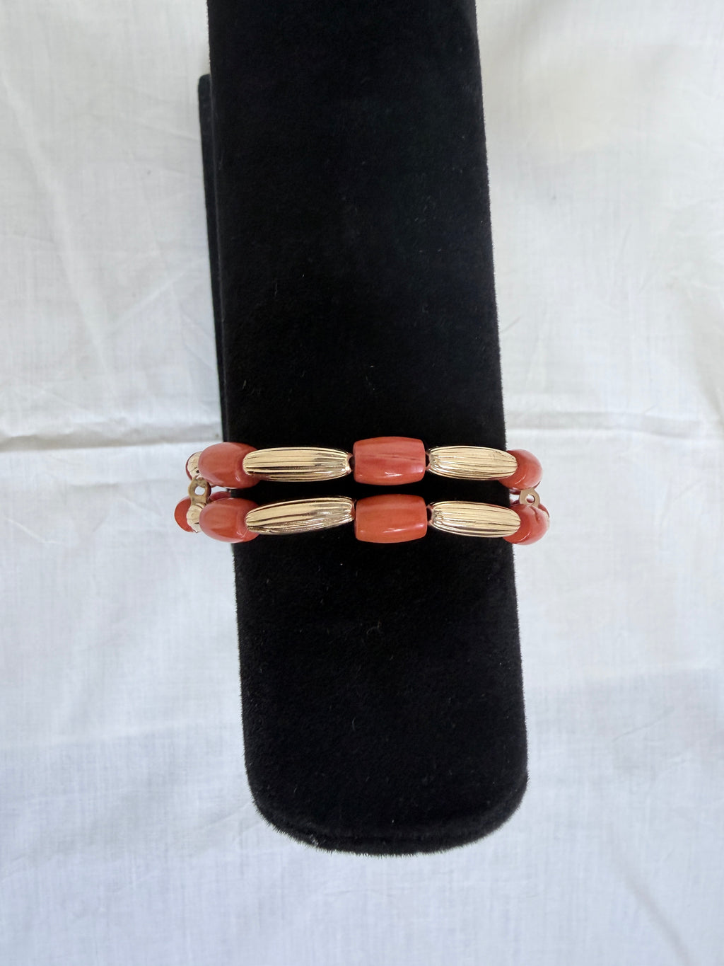 "Coral tube two-row bracelet on black velvet stand showing front view of double row design with alternating coral and gold beads"