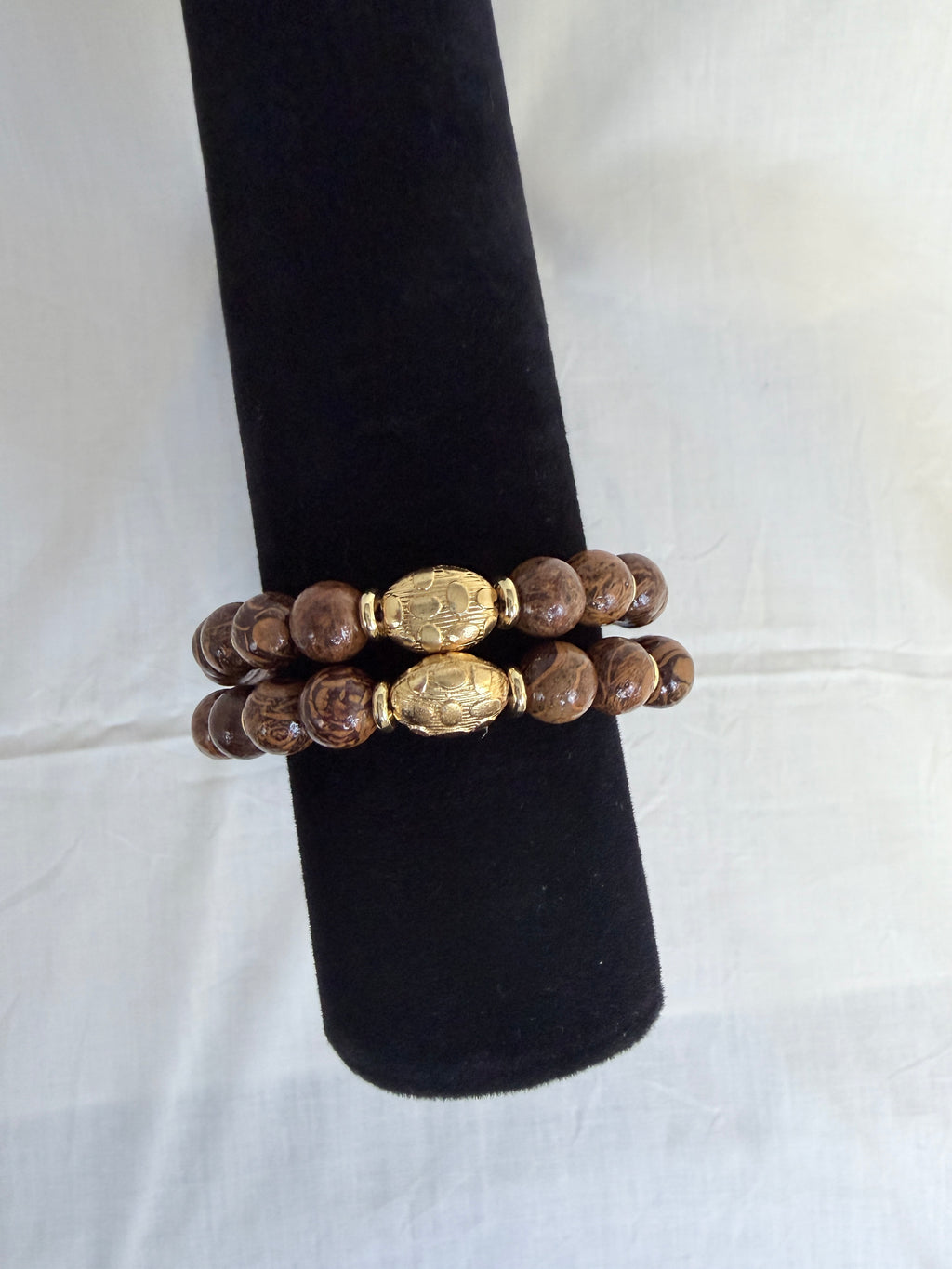 "Two elephant skin jasper bracelets stacked on black velvet stand showing how they look layered together"