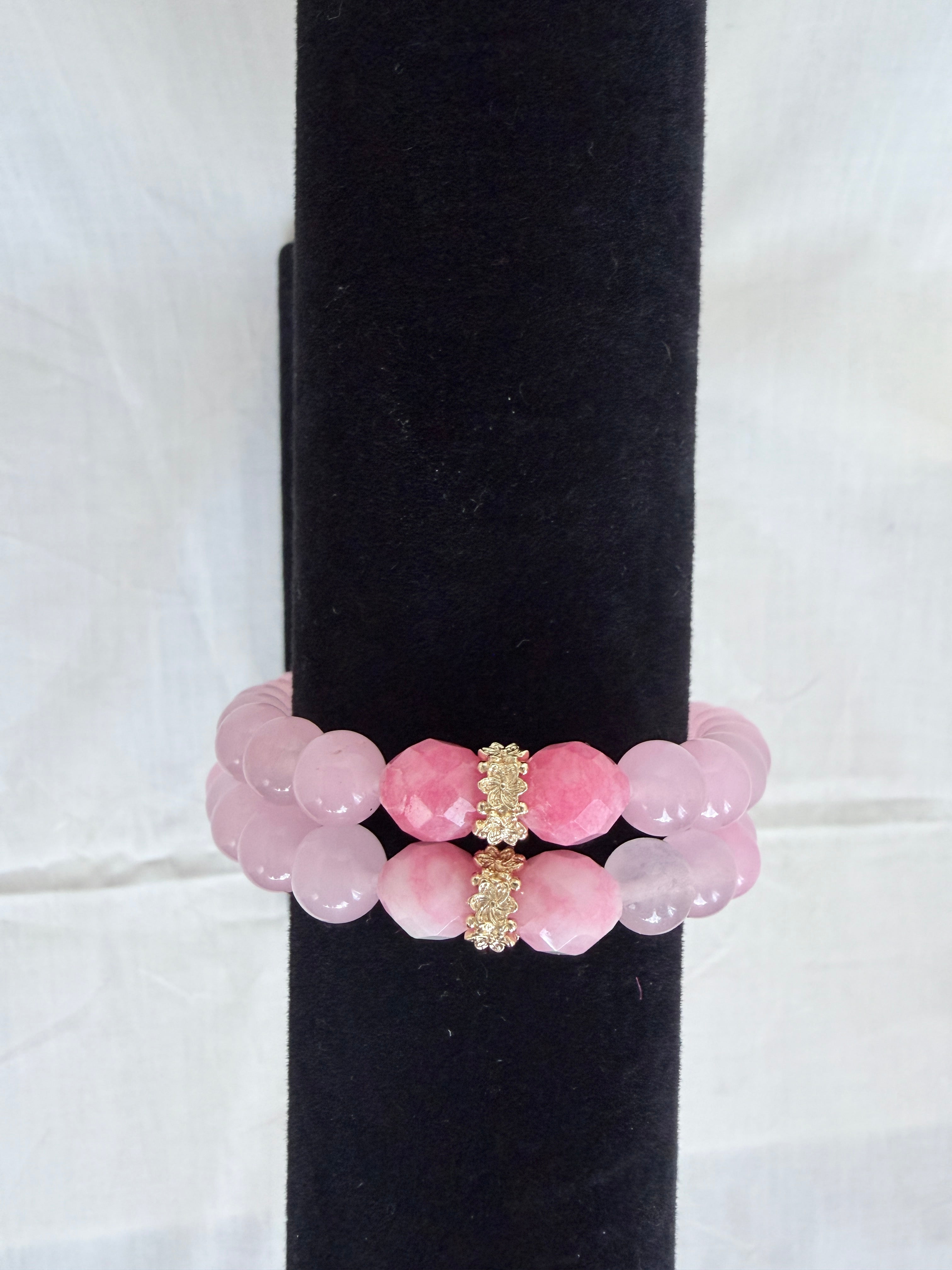 "Two pink jade and candy bracelets stacked on black velvet stand showing how they look layered together with gold  rondelle centrepieces"