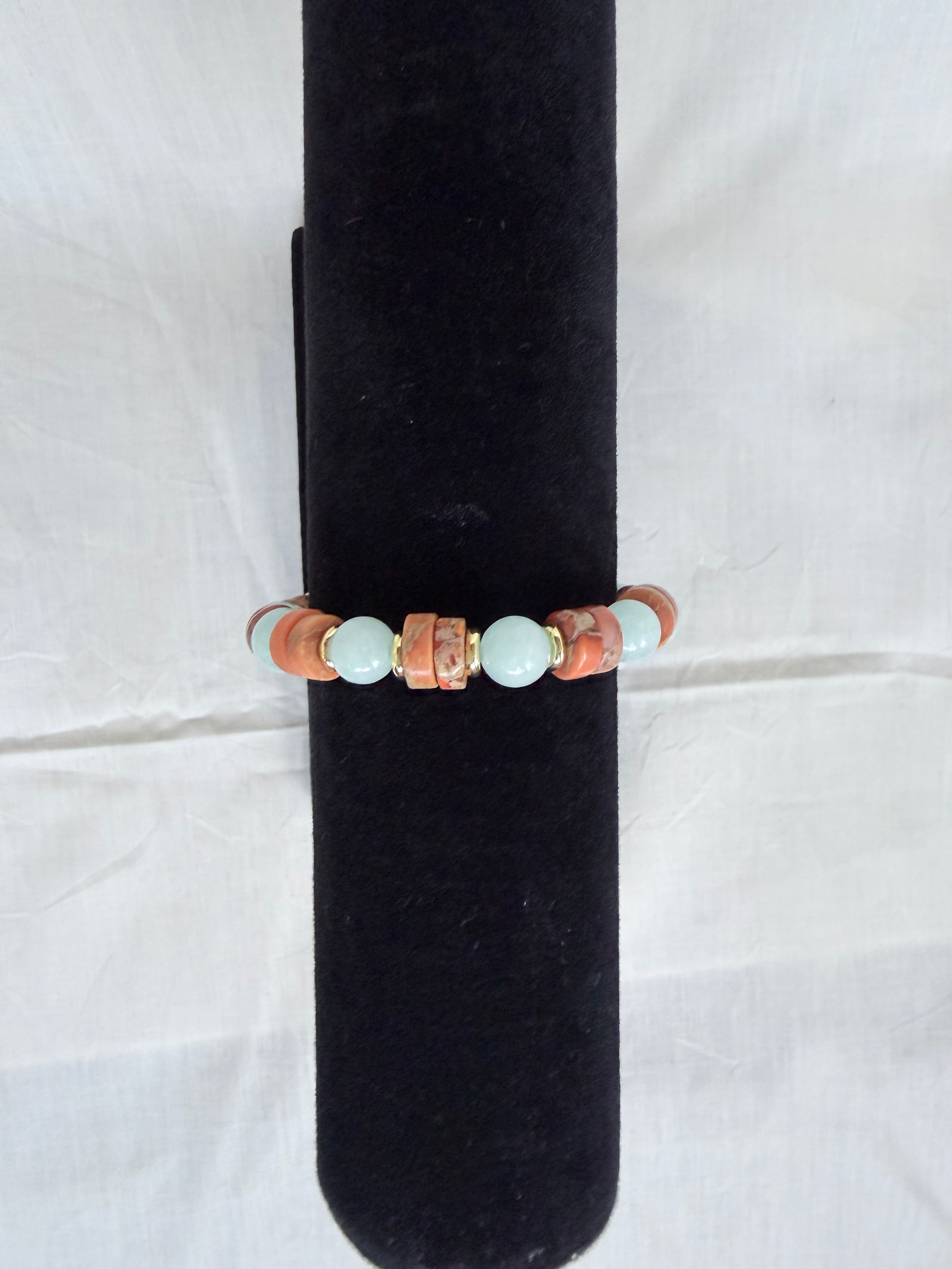 "Jasper and aqua agate bracelet on black velvet stand showing side view of orange-brown jasper wheel beads contrasting with aqua agate beads"