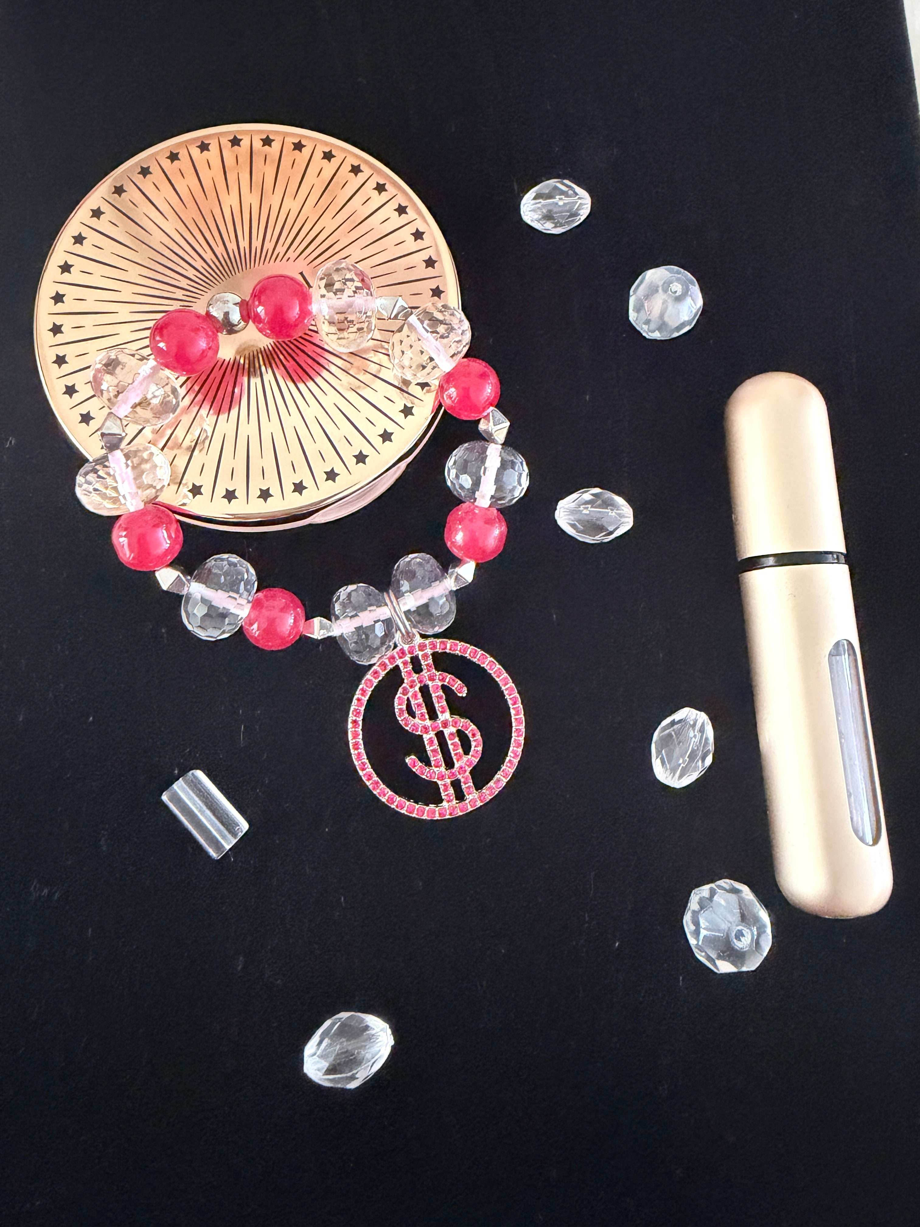 Money Moves Charm Bracelet flat lay on black velvet with clear rhinestones, gold compact mirror and perfume bottle