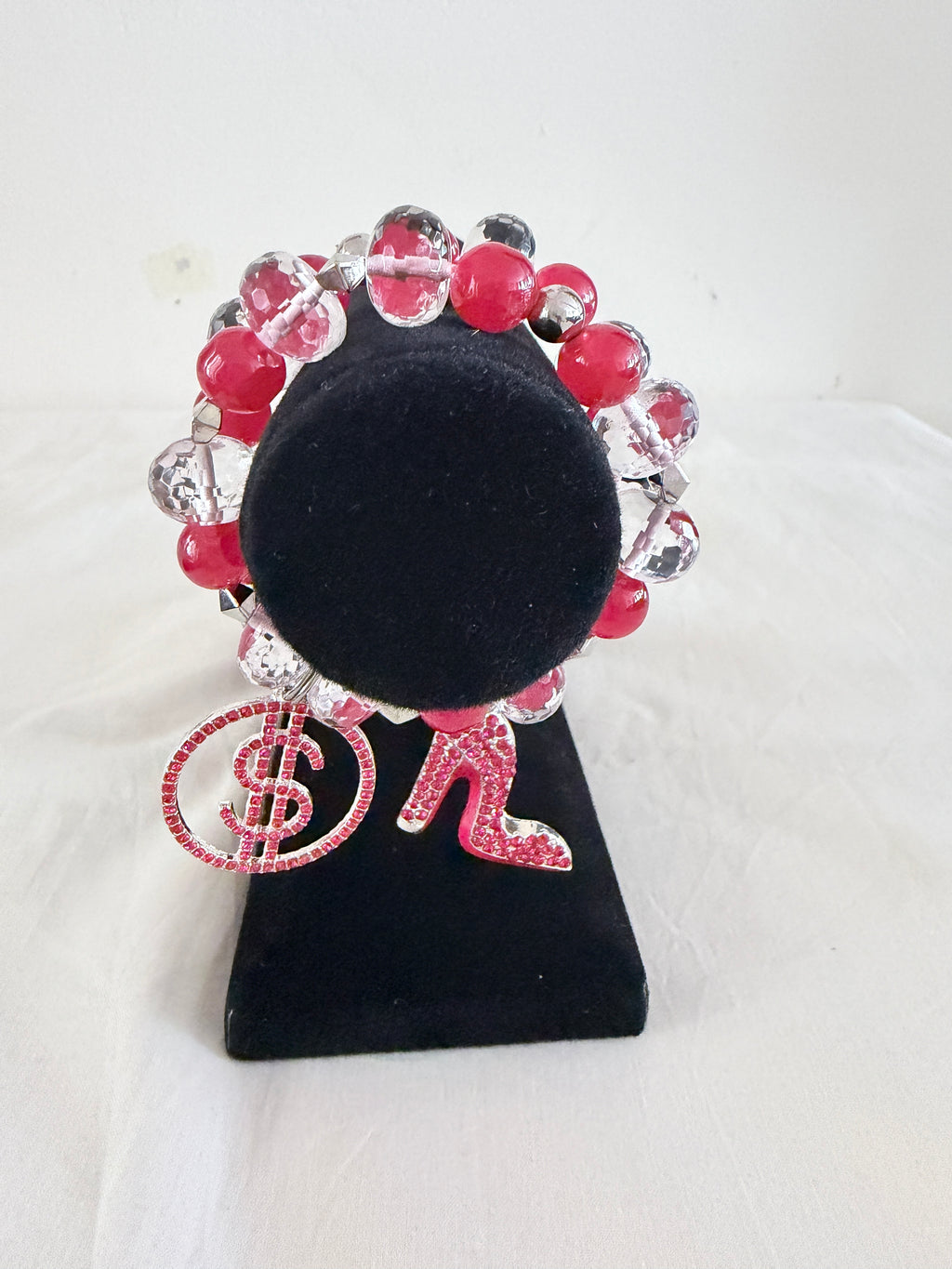 Boss Lady and Money Moves Charm Bracelets stacked together on black velvet stand showing both dollar sign and stiletto heel charms