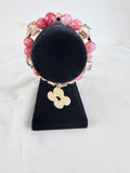 Flower Power Charm Bracelet on black velvet stand showing pearlised gold flower charm with mottled pink orange and champagne gold cube beads