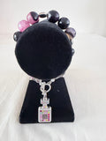 Scent of Luxury Charm Bracelet on black velvet stand showing multicolour rhinestone silver perfume bottle charm with purple banded agate beads and silver bell end caps