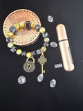 Lime and black cube bead bracelet with gold lock and key charms on dark background