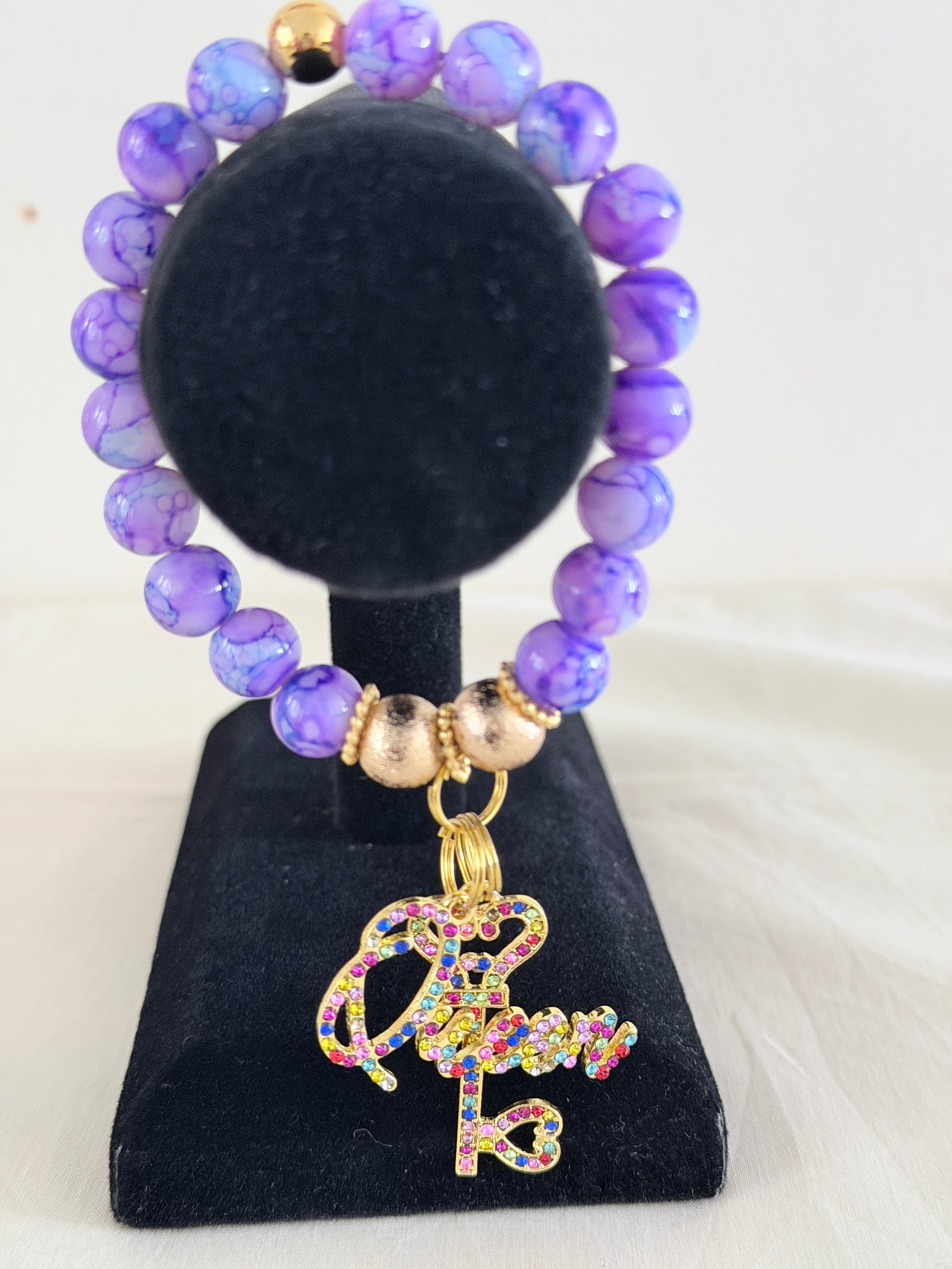 Purple marble bead bracelet with multicolour rhinestone Queen crown key charm on black jewellery stand - LoyatobsCreations.com