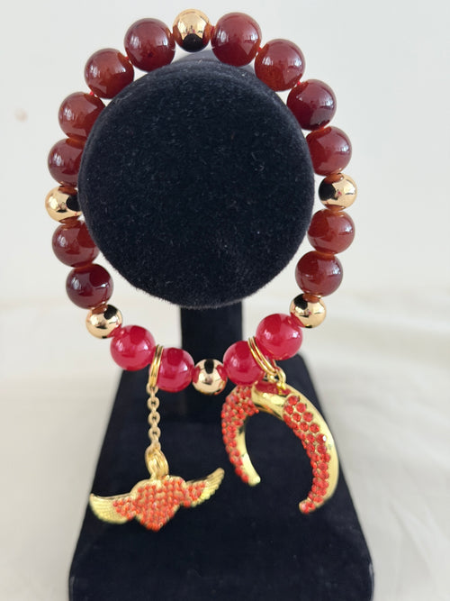 Burgundy ceramic bead bracelet with gold rhinestone crescent moon and winged heart charms on black jewellery stand - LoyatobsCreations.com