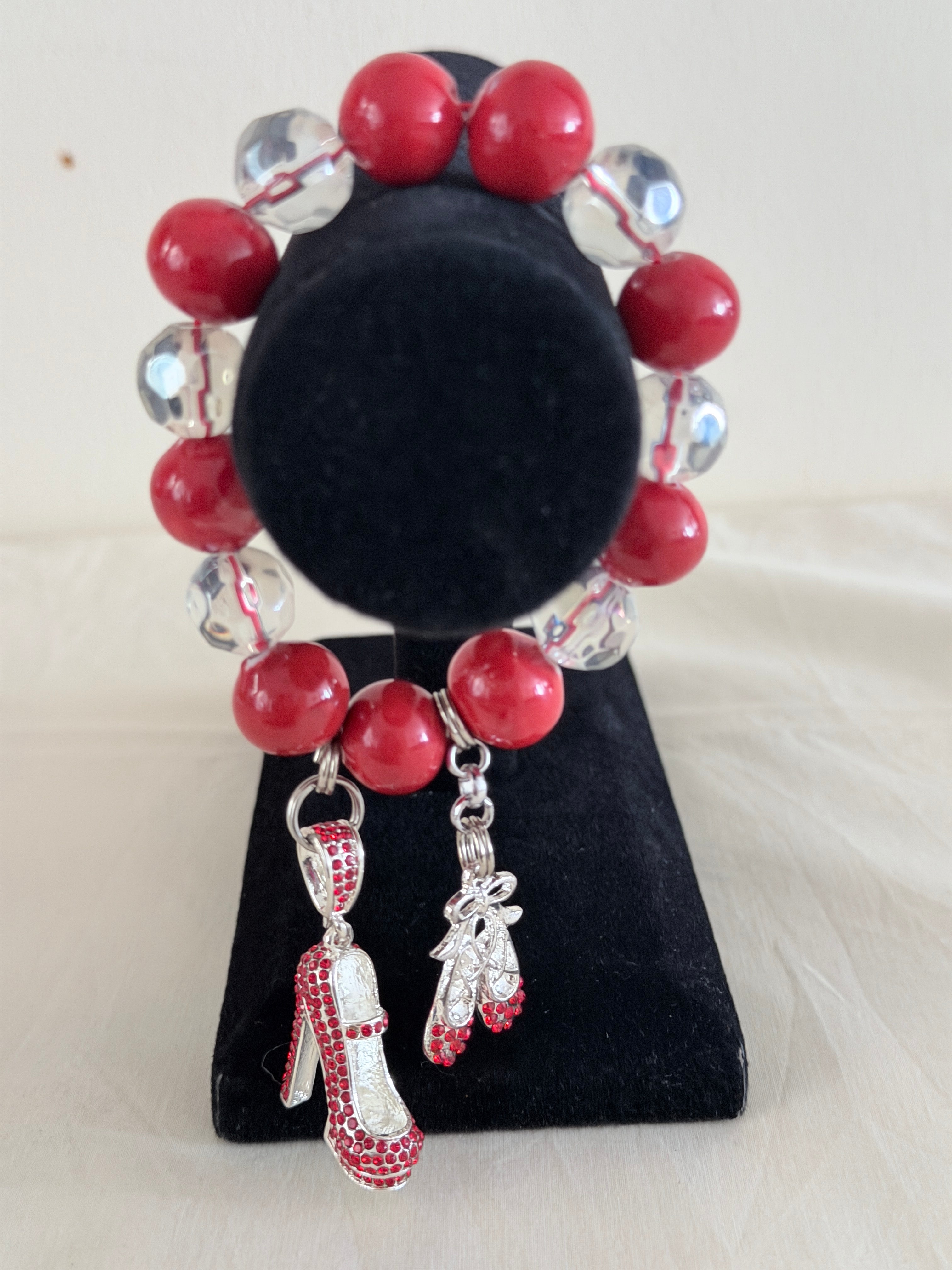 Coral pink and crystal bead bracelet with silver rhinestone stiletto and ballet slipper charms on black jewellery stand - LoyatobsCreations.com