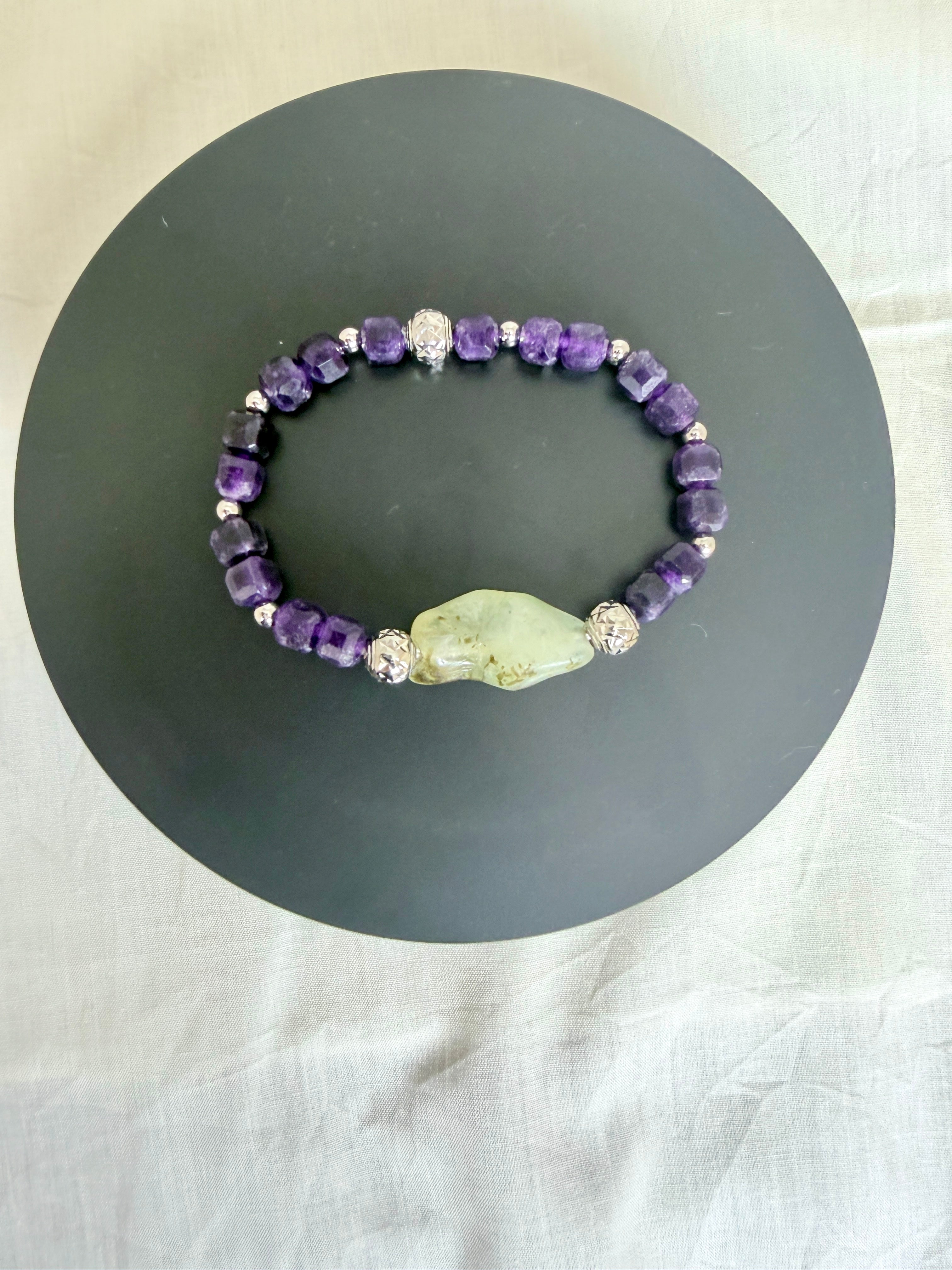 "Amethyst and green prehnite elasticated bracelet laid flat on a grey circle board showing full bracelet design"