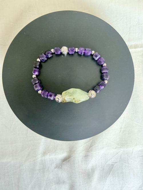 "Amethyst and green prehnite elasticated bracelet laid flat on a grey circle board showing full bracelet design"