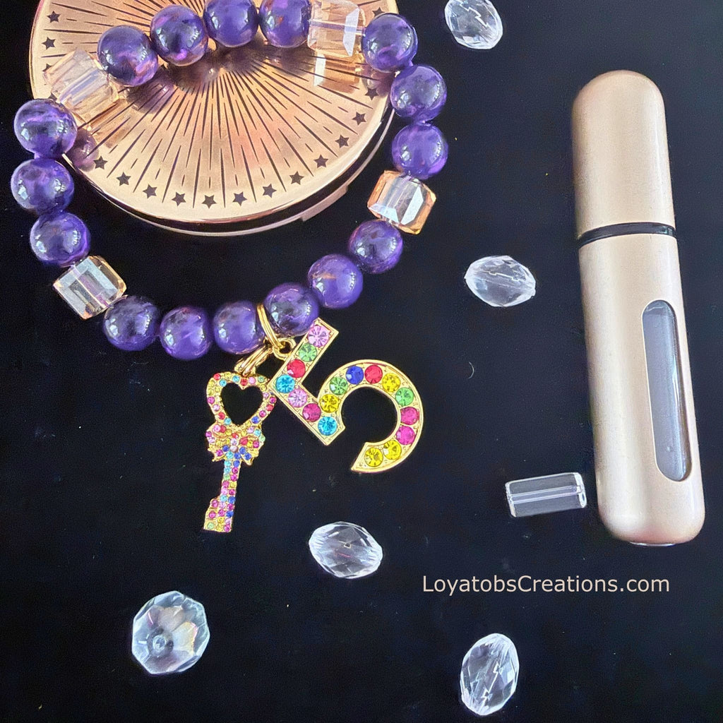 "Purple bead and champagne cube crystal charm bracelet with multicolour rhinestone charms on dark background"
