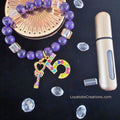 "Purple bead and champagne cube crystal charm bracelet with multicolour rhinestone charms on dark background"