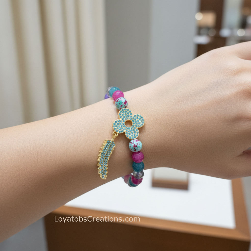 Multicolour mixed bead bracelet with gold turquoise rhinestone flower and feather charms worn on wrist - LoyatobsCreations.com